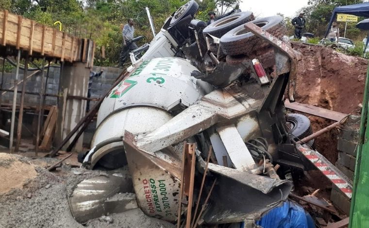 Homem morre e outro fica ferido após caminhão com concreto cair em buraco na Grande BH