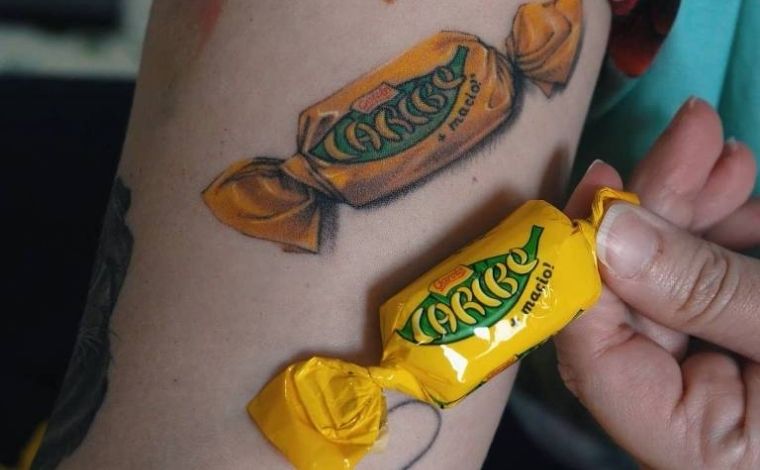 Mulher viraliza nas redes sociais após tatuar bombom ‘Caribe’ no braço e ganhar 10kg do chocolate