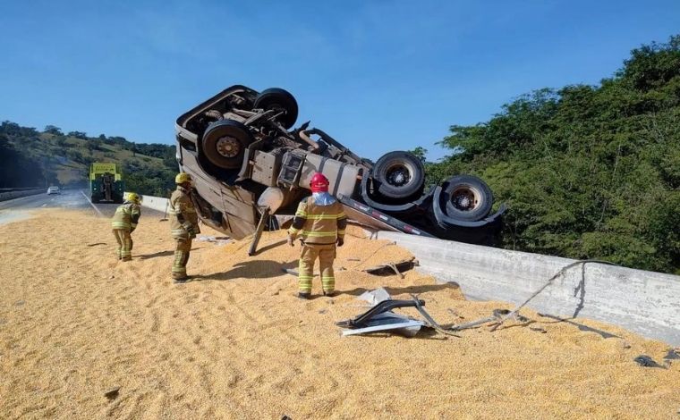 Carreta carregada com milho fica pendurada em ponte após tombamento na BR-050, em MG