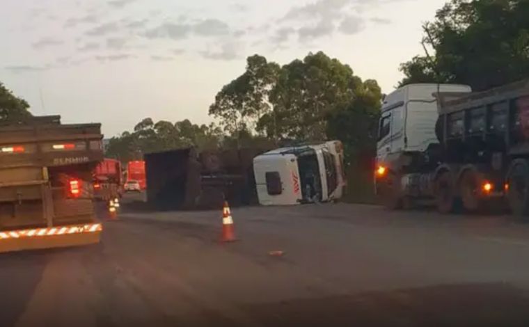 Carreta com minério tomba na BR-040 e carga fica espalhada na pista; trânsito segue em pare e siga  