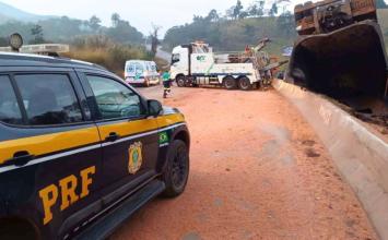Motorista morre após carreta carregada com sorgo tombar e interditar a BR-040