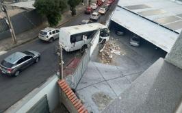 Micro-ônibus atinge muro de imóvel e fica pendurado em Belo Horizonte