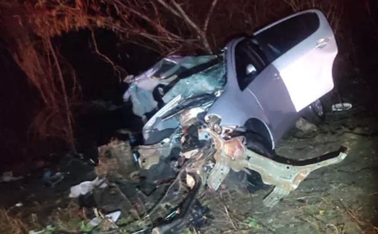 Foto: DivulgaÃ§Ã£o/Corpo de Bombeiros - O carro ficou totalmente destruÃ­do e retorcido com o impacto da batida. Os corpos ficaram entre Ã s ferragens, mas nÃ£o estavam presos. No carro viajavam um homem, uma mulher e uma adolescente