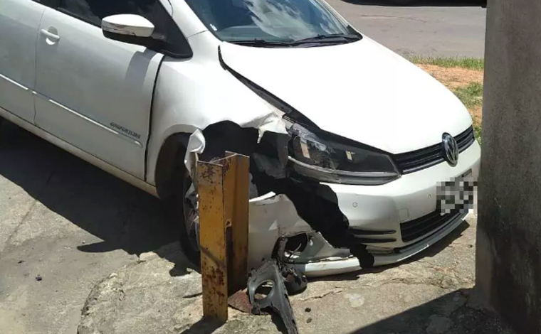 Foto: DivulgaÃ§Ã£o/PMMG - Enquanto fugia da polÃ­cia, o suspeito colidiu com outro veÃ­culo e foi arremessado contra uma barra de contenÃ§Ã£o na porta de uma residÃªncia. Ele desceu do carro e continuou a fuga a pÃ©, chegando atÃ© atravessar um cÃ³rrego 