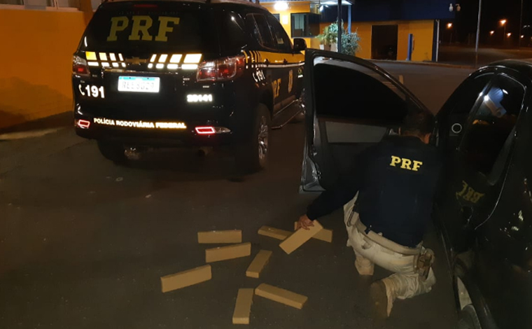 Foto: DivulgaÃ§Ã£o/PRF - Ao realizarem vistoria no interior do carro, os policiais localizaram um saco plÃ¡stico preto com 11 tabletes do entorpecente conhecido por maconha, totalizando aproximadamente 10 kg do entorpecente